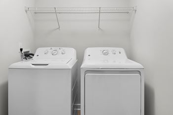 Two white front loading washing machines in a laundry room.
